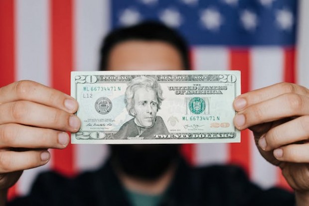 Man holding 20 U.S. Dollars