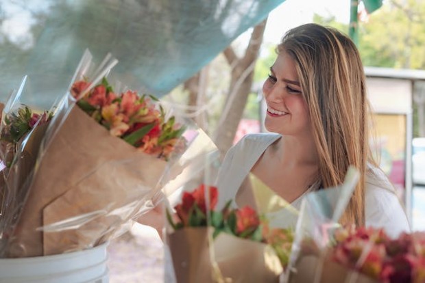 A woman looking at flower bouquets