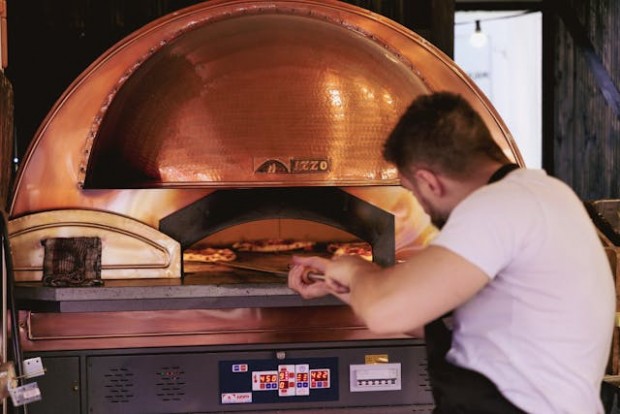Man preparing pizza dough in a furnance