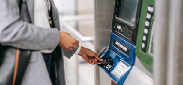 A person inserting ATM card into a machine