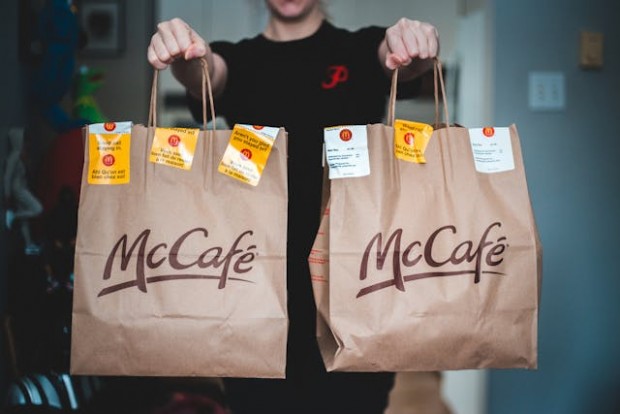 A person holding two paper bags from McDonald's
