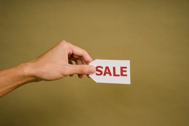 A person holding a Sale tag