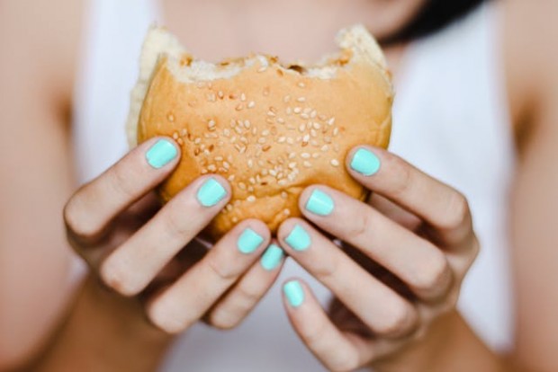 A woman holding a burger