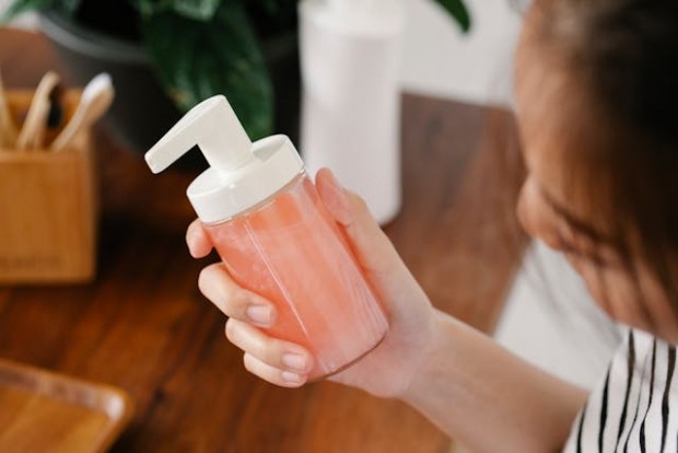 A woman holding a soap dispenser