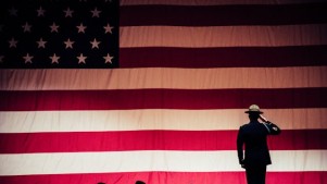 A man standing in front of a American FLag