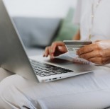 A person using her laptop while holding a card