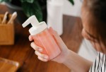 A woman holding a soap dispenser